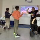 Learning Centre teacher stands in front of students and leads active activity.